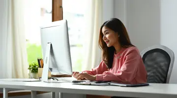 Eine Frau die vor einem Computer sitzt