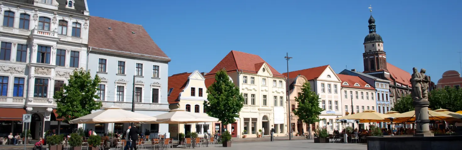 Der Marktplatz in Cottbus mit einem Springbrunnen in der Mitte und drumherum mehrstöckige Häuser