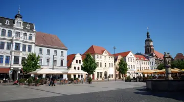 Der Marktplatz in Cottbus mit einem Springbrunnen in der Mitte und drumherum mehrstöckige Häuser