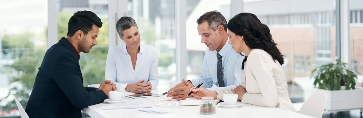 Eine Gruppe von Planerinnen und Planern arbeitet an einer kommunalen Wärmeplanung. Im Hintergrund Bürogebäude.