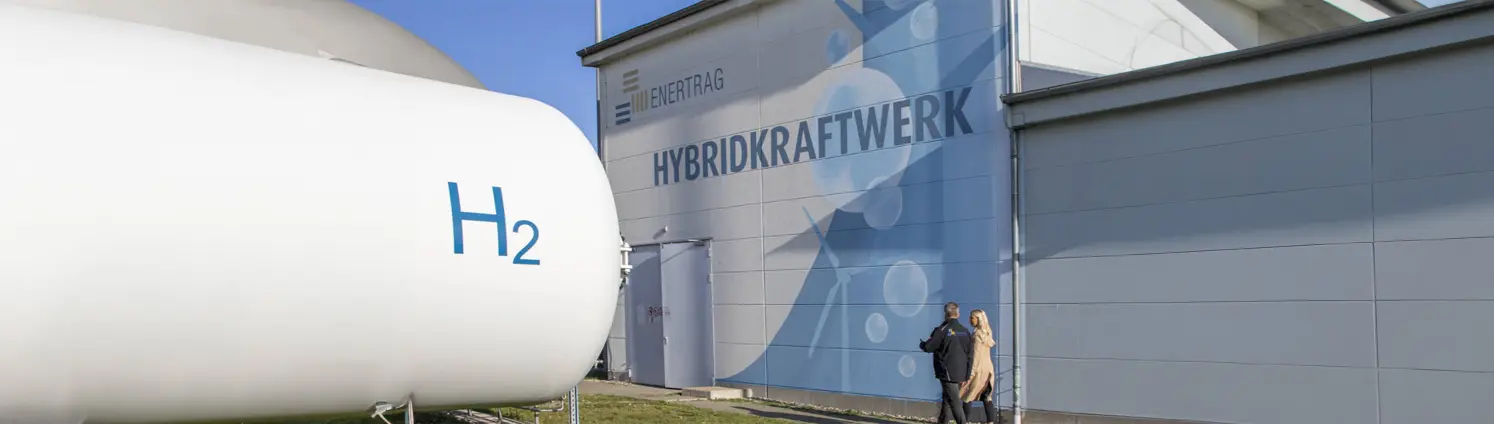 Ein Wasserstoff-Behälter vor einem Hybridkraftwerk-Gebäude