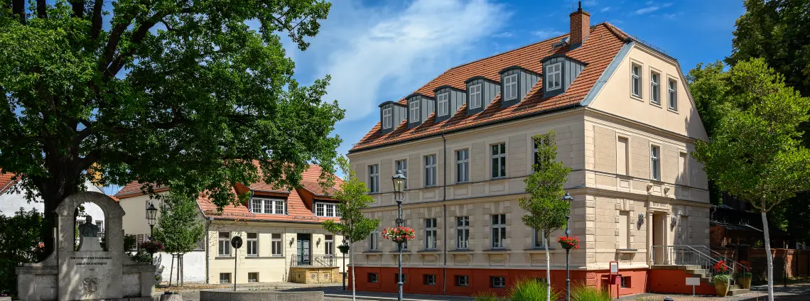 Das Rathaus Teltow in orange mit geschmücktem Richtfest-Baum davor