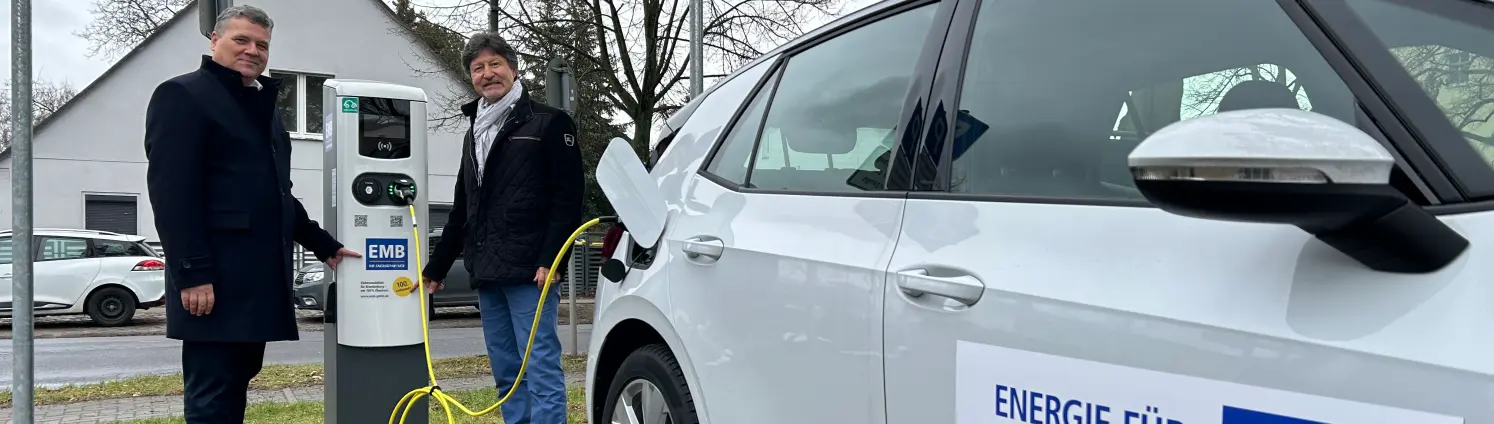 Zwei Personen betanken ein weißes EMB-E-Auto an der neuen Ladensäule in Mühlenbeck